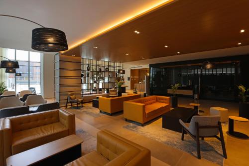 a living room with couches and tables and chairs at Radisson Hotel & Residence Riyadh Olaya in Riyadh