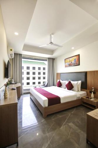 a bedroom with a large bed and a large window at Saltstayz Premier - Cyber Hub in Gurgaon