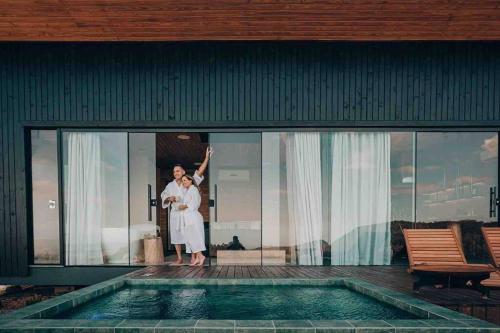 a man standing on the window of a house next to a swimming pool at Quinta do Céu Refúgio in Gravatal