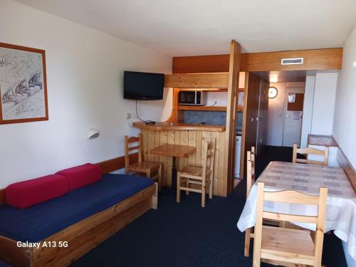 Cette chambre comprend un lit, une table et une cuisine. dans l'établissement Studio skis aux pieds à Arc 1800, 5 pers, proche commerces et remontées - FR-1-411-243, à Arc 1800