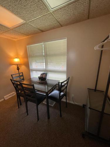 a dining room with a table and chairs and a window at Magnolia APT 1 in Lansing