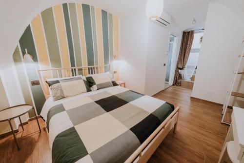 a bedroom with a bed with a striped wall at La casa di Achille in Chieti