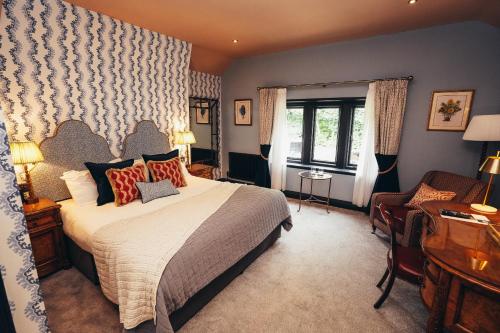 a hotel room with a bed and a desk at The George in Hathersage