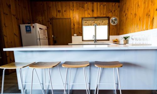 a kitchen with a counter with stools at a bar at The View, Metung in Metung