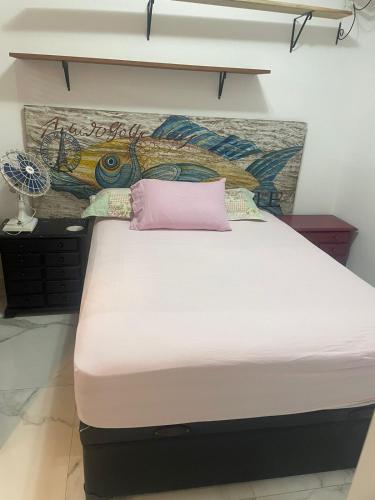 a bed with a pink pillow on top of it at Sala living 809 in São Vicente