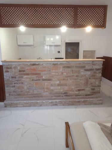 a kitchen with a brick wall and a counter at R4 Rolléder Apartman-ház in Siklós