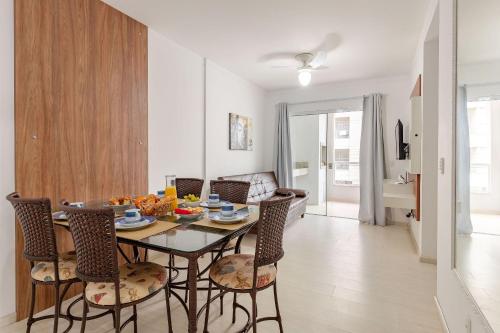 a dining room and living room with a table and chairs at Excelente Apartamento a 2 minutos da Praia de Bombas in Bombas