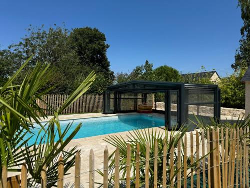 une piscine à structure noire à côté d'une clôture dans l'établissement Gîte de l'Epicerie, à Nottonville