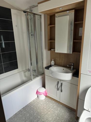 a bathroom with a sink and a shower and a toilet at Lakeside Dorchester Lodge - Hot Tub with Fishing Peg in Tattershall