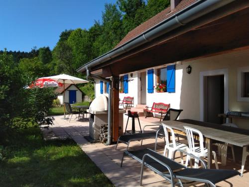 a patio with chairs and a table and an umbrella at Vogesenparadies in Kirchberg