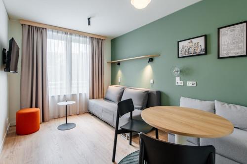 a living room with a couch and a table at Aparthotel Adagio Muenchen City in Munich