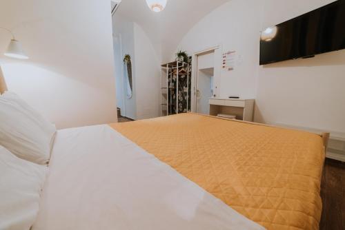 a bedroom with a large bed with a yellow blanket at La casa di Achille in Chieti