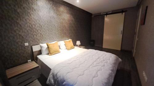 een slaapkamer met een groot wit bed met gele kussens bij Studio ALMASSIRA in Casablanca