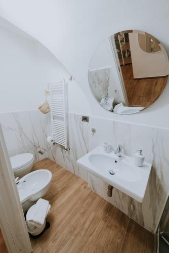 a bathroom with a sink and a toilet and a mirror at La casa di Achille in Chieti