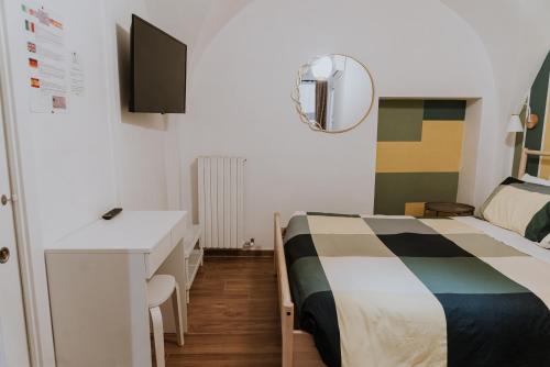 a bedroom with a bed and a desk and a tv at La casa di Achille in Chieti