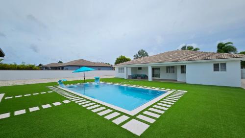 a yard with a swimming pool and a house at Sunny Oasis with private pool in Homestead