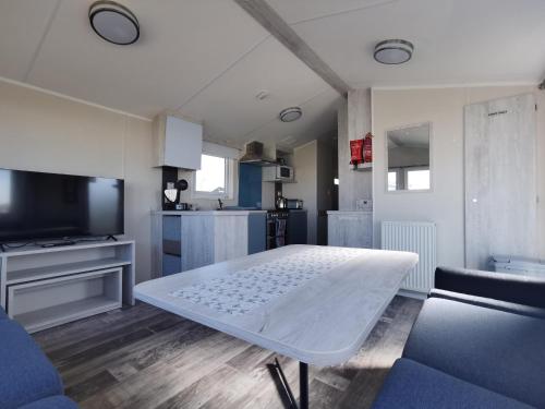 a living room with a white table and a tv at Golden Sands sea holiday beach activities and relax in Mablethorpe