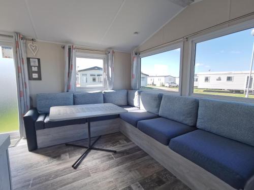 a living room with blue couches and a table at Golden Sands sea holiday beach activities and relax in Mablethorpe