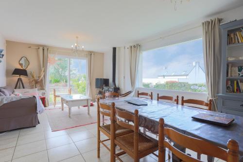 un salon avec une table à manger et un salon avec un canapé dans l'établissement Maison Familiale Kerlaho - Vue Mer, à Trébeurden