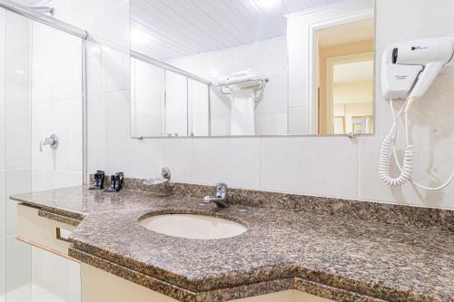 a bathroom with a sink with a hair dryer at H4 Fortune Jardins in Sao Paulo