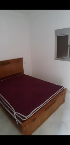 a wooden bed in a white room with at Douas dalia in Dalia