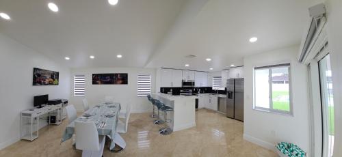 a white salon with a table and chairs in a room at Sunny Oasis with private pool in Homestead