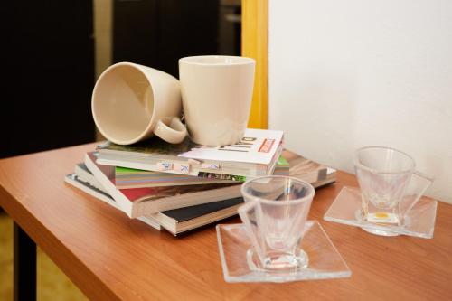 a table with two glasses and a pile of books at Rustico in borgo Polcenigo in Polcenigo