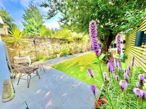 a garden with purple flowers and a fence at Family Three Bedroom Home - Outbuilding Games Room - Walk to Town and Beach - Free Parking in Bournemouth