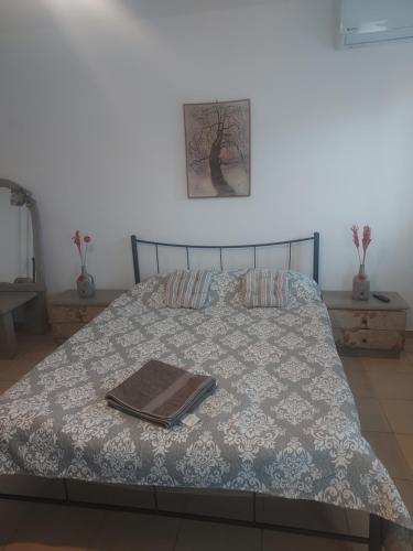a bed with a blanket and a book on it at Dina in Palaiá Fókaia