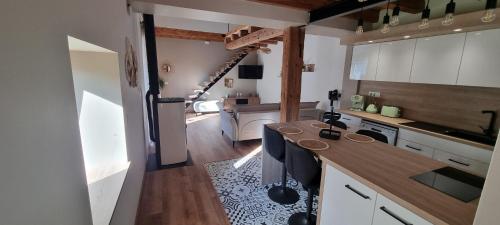 une cuisine avec des armoires blanches et un comptoir dans l'établissement la grange de Guew, à Guewenheim