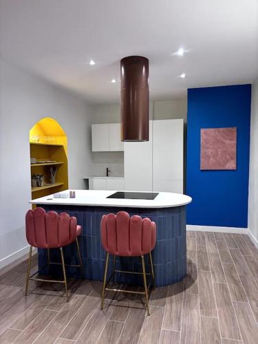 une cuisine avec comptoir et tabourets rouges dans l'établissement La maison de Vaina et Marius, à La Seyne-sur-Mer