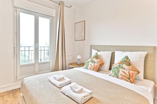 ein Schlafzimmer mit einem großen Bett, auf dem Handtücher liegen in der Unterkunft Studio agréable et tout équipé - Montreuil in Montreuil