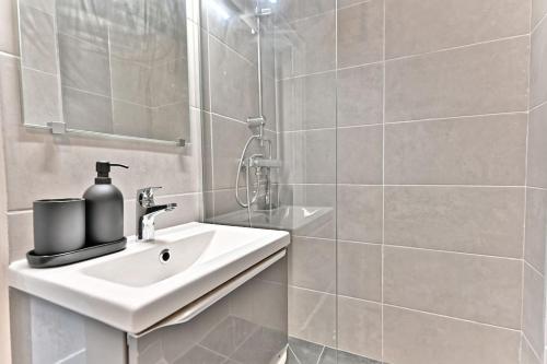 ein weißes Badezimmer mit Waschbecken und Spiegel in der Unterkunft Studio agréable et tout équipé - Montreuil in Montreuil