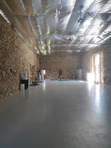 une grande pièce avec un sol blanc et des murs en briques dans l'établissement Le Dojo, à Saint-Christophe