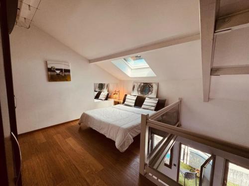 une chambre avec un lit et une lucarne dans l'établissement Loft vue sur Lac d'Annecy et Montagnes, à Annecy