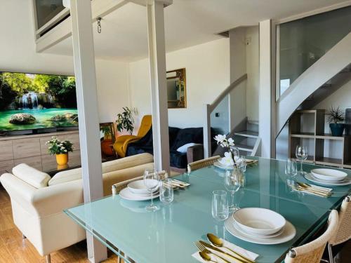une salle à manger avec une table en verre et un canapé dans l'établissement Loft vue sur Lac d'Annecy et Montagnes, à Annecy