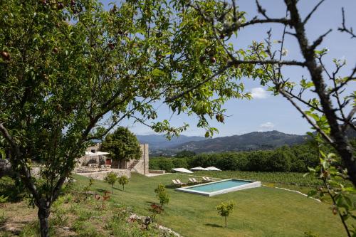 a garden with a swimming pool in the grass at Quinta do Outeiro 1598 in Ponte da Barca
