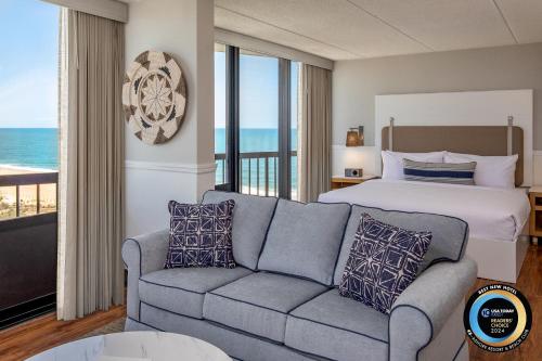 a bedroom with a bed and a couch with a view at Ashore Resort & Beach Club in Ocean City