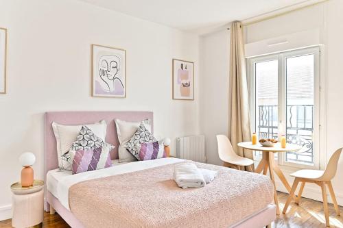 une chambre blanche avec un grand lit et une table dans l'établissement Magnifique studio neuf au centre de Montreuil, à Montreuil