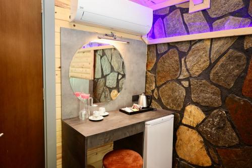 a bathroom with a stone wall with a mirror at Yamacda Suit Otel in Çamlıhemşin