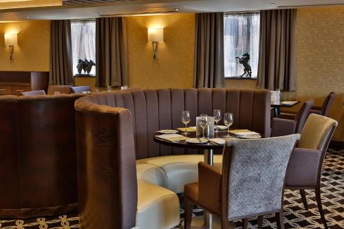 a restaurant with a table and chairs with wine glasses at Best Western Heath Court Hotel in Newmarket