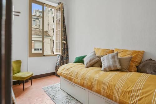 une chambre avec un lit, une fenêtre et une chaise dans l'établissement AMICAL-Marseille-Coeur de ville Balcon, à Marseille