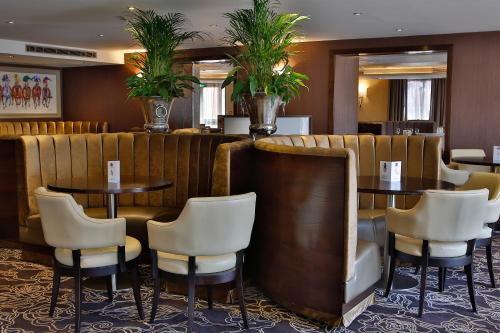 a restaurant with two tables and chairs and plants at Best Western Heath Court Hotel in Newmarket