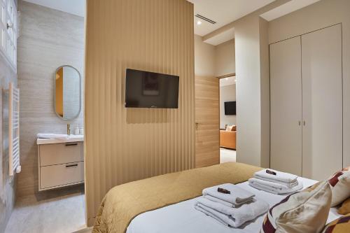 une chambre avec un lit et une télévision sur un mur dans l'établissement Residence Center of Paris by Studio Prestige, à Paris