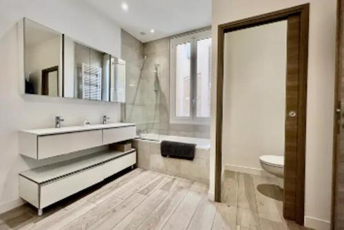 une salle de bain avec un lavabo, une baignoire et des toilettes dans l'établissement Stylish 3-bedroom Gem Steps From Monaco Spacious, à Beausoleil