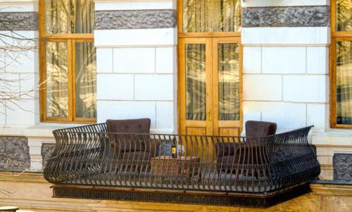 a bench in front of a building with windows at Belona Hotel in Kutaisi