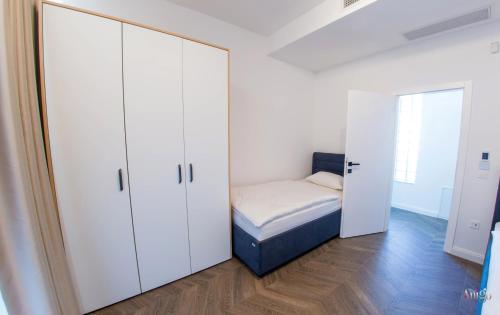 a small bedroom with a bed and white cabinets at Villa River in Mostar