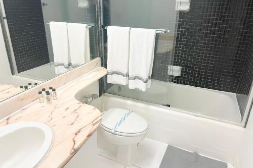 Un baño con lavabo, inodoro y bañera. en Miami Beach Apartments by MiaRentals, en Miami Beach
