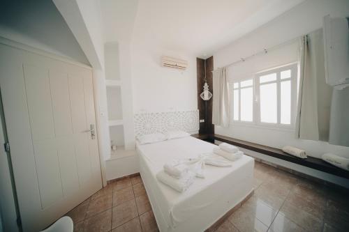 a white room with a bed and a window at Villa Ilias in Firostefani