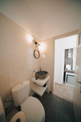 a bathroom with a white toilet and a sink at Villa Ilias in Firostefani